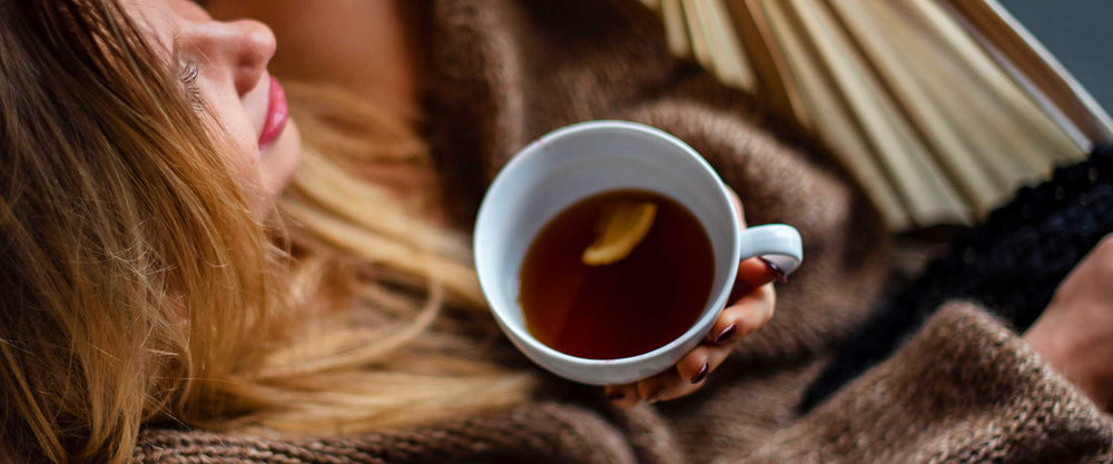 Woman lounging and sipping adaptogen tea for immunity